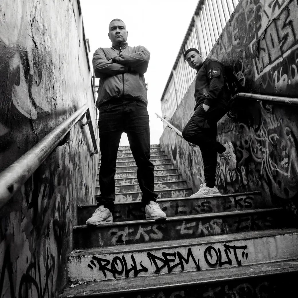 Roll Dem Out album cover — Benny Page and Doktor on a graffiti-covered stairwell, the title tagged across the steps